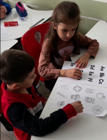 1B sınıfı öğrencileri English Main Course dersinde Phonics çalışması yaptı, öğrendikleri sesleri sıra arkadaşlarıyla tekrar etti.